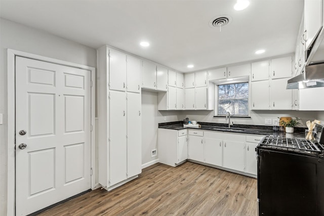 kitchen featuring white cabinetry, sink, light hardwood / wood-style floors, and gas stove