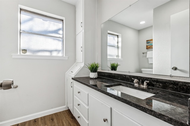 bathroom with hardwood / wood-style flooring, vanity, and toilet