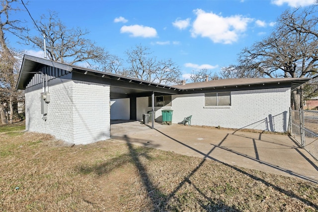 rear view of house featuring a carport and a lawn