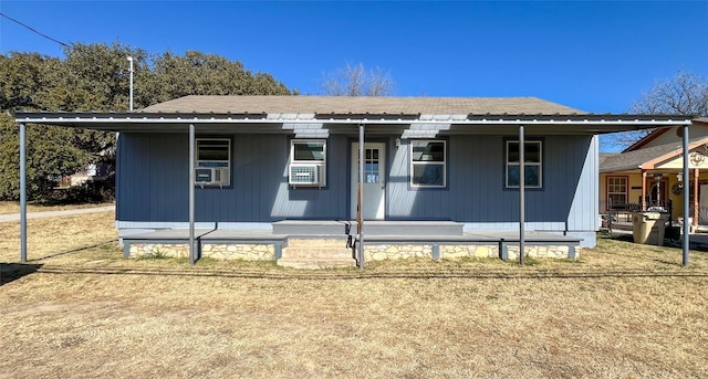 view of front facade featuring cooling unit, a front lawn, and a porch