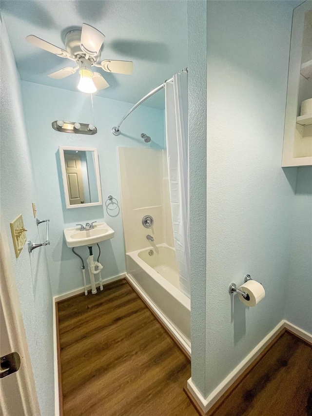 full bathroom with washtub / shower combination, ceiling fan, baseboards, and wood finished floors