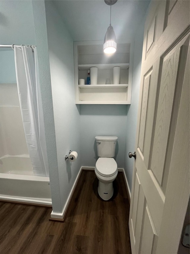 bathroom featuring a stall shower, wood finished floors, toilet, and baseboards