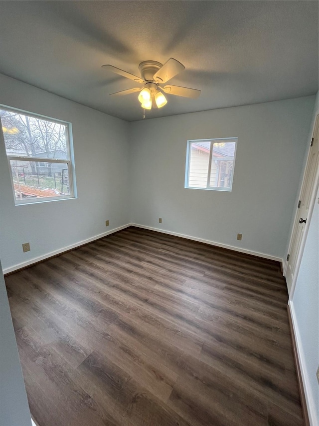 unfurnished bedroom with a textured ceiling, dark wood-type flooring, a ceiling fan, and baseboards