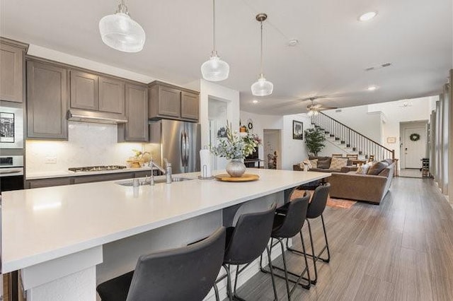 kitchen with pendant lighting, sink, a breakfast bar, appliances with stainless steel finishes, and a spacious island