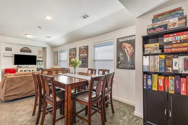 dining room with lofted ceiling and carpet