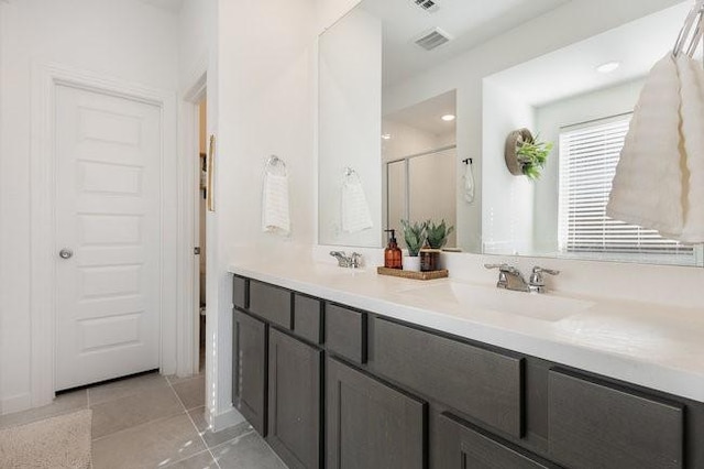 bathroom with vanity, a shower with shower door, and tile patterned flooring