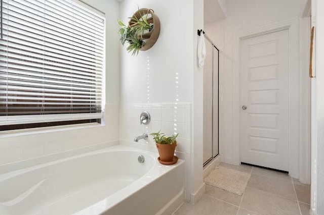 bathroom with tile patterned floors and shower with separate bathtub