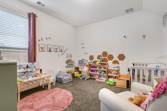 bedroom featuring vaulted ceiling, a nursery area, and carpet flooring