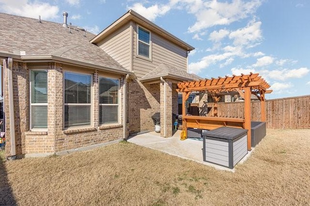 back of house featuring a lawn, a patio area, and a pergola