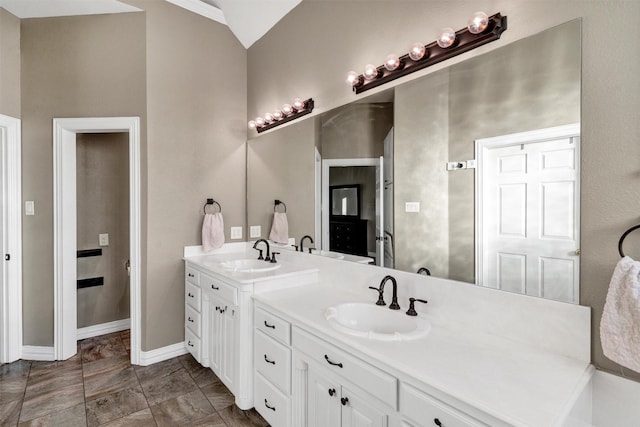 bathroom featuring vanity, lofted ceiling, and crown molding