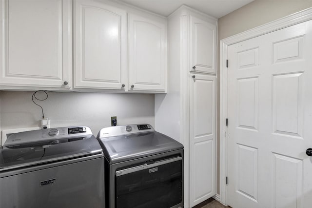 laundry area with separate washer and dryer and cabinets