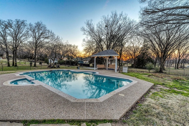 pool at dusk featuring a gazebo, a patio, and an in ground hot tub