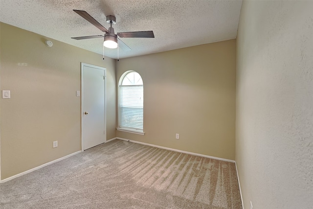 carpeted empty room with ceiling fan and a textured ceiling