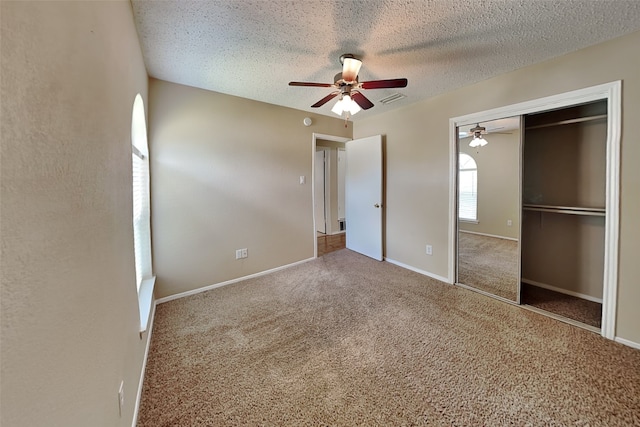 unfurnished bedroom with ceiling fan, carpet flooring, a closet, and a textured ceiling