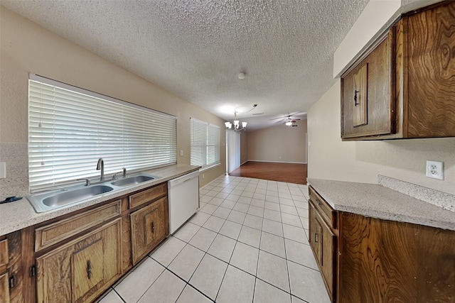 kitchen featuring ceiling fan with notable chandelier, sink, light tile patterned floors, white dishwasher, and a textured ceiling