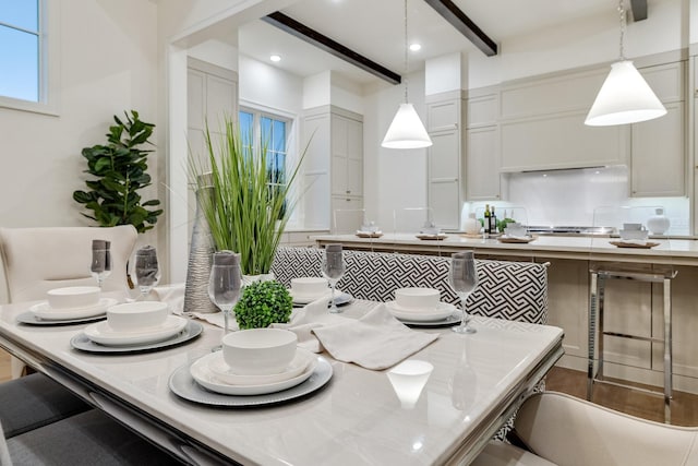 dining space with beam ceiling