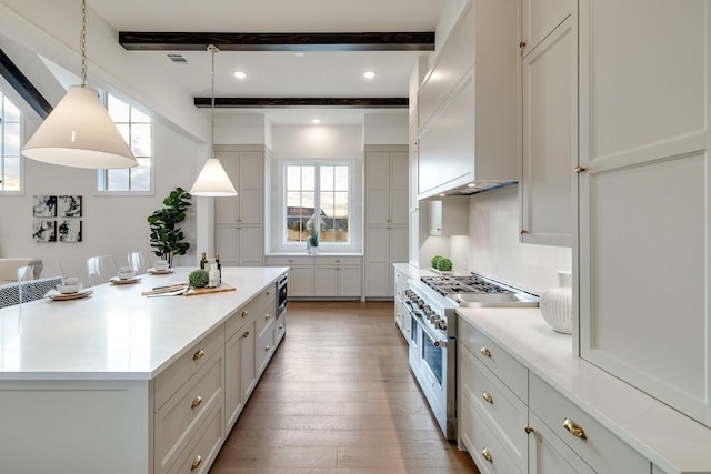 kitchen with pendant lighting, double oven range, beam ceiling, a spacious island, and custom exhaust hood