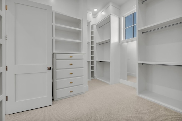 walk in closet with light carpet