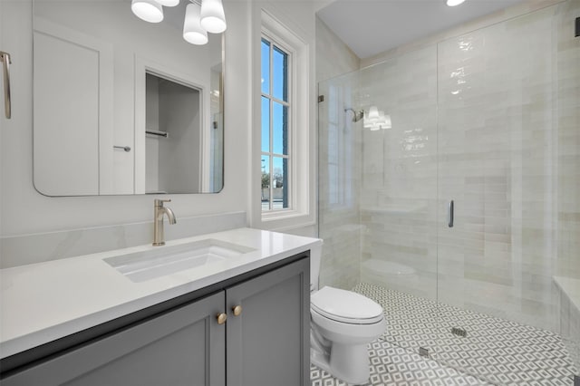 bathroom with walk in shower, vanity, and toilet