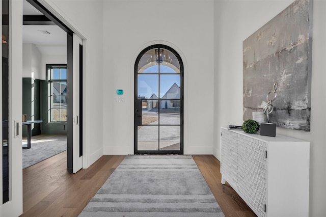 foyer entrance featuring dark wood-type flooring and an inviting chandelier