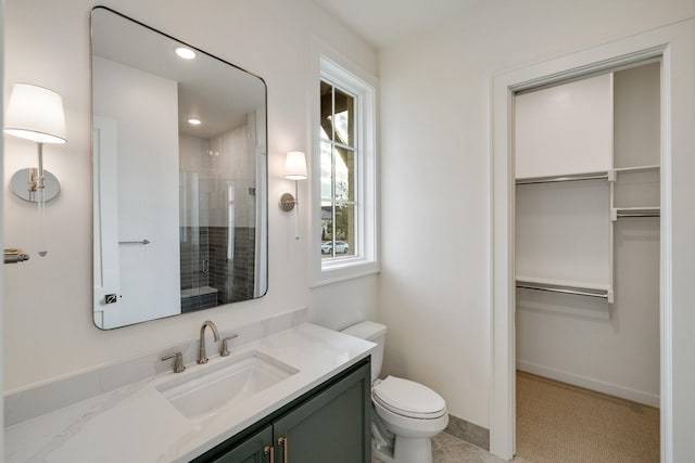 bathroom with an enclosed shower, vanity, and toilet