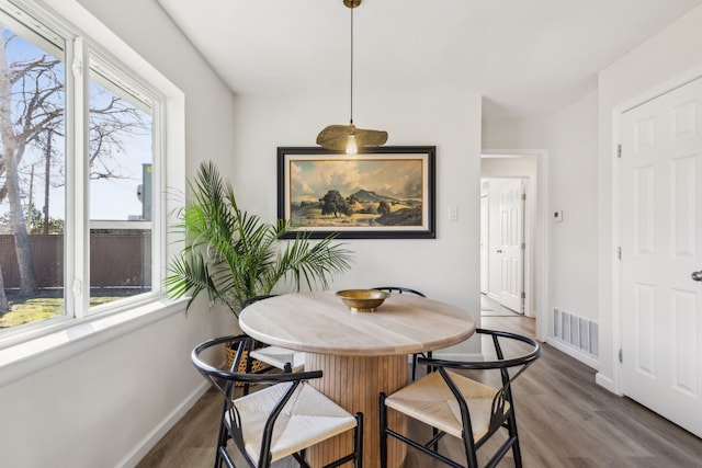 dining room featuring visible vents, baseboards, and wood finished floors