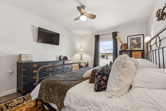 bedroom with ceiling fan, baseboards, and wood finished floors