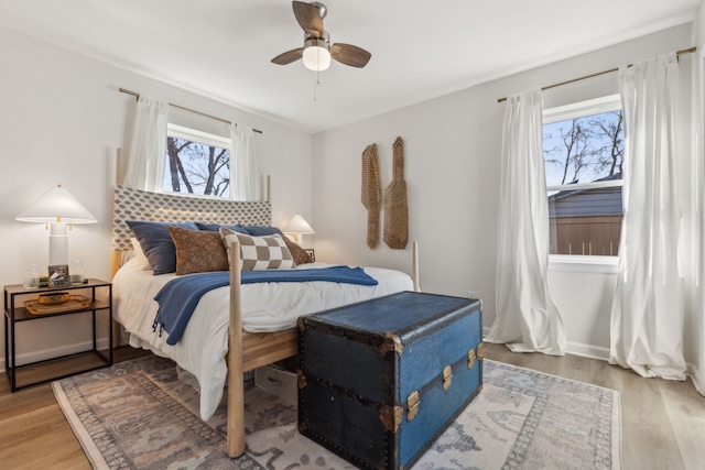 bedroom with a ceiling fan, light wood-type flooring, and baseboards