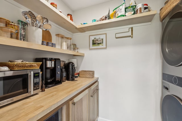 interior space featuring stacked washer / drying machine and wood counters