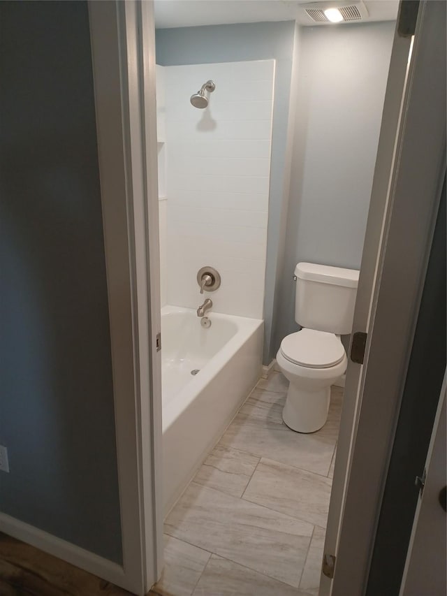 bathroom featuring tub / shower combination and toilet