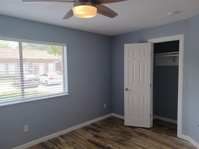 unfurnished bedroom with dark hardwood / wood-style floors, a closet, and ceiling fan