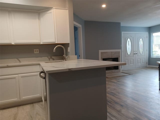 kitchen featuring white cabinetry, light stone countertops, sink, and kitchen peninsula