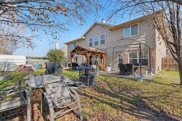 rear view of property featuring a gazebo, a patio, and a lawn