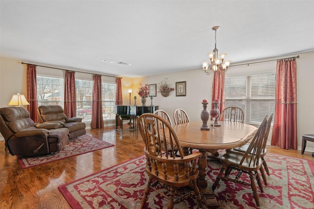 dining area featuring an inviting chandelier and hardwood / wood-style floors