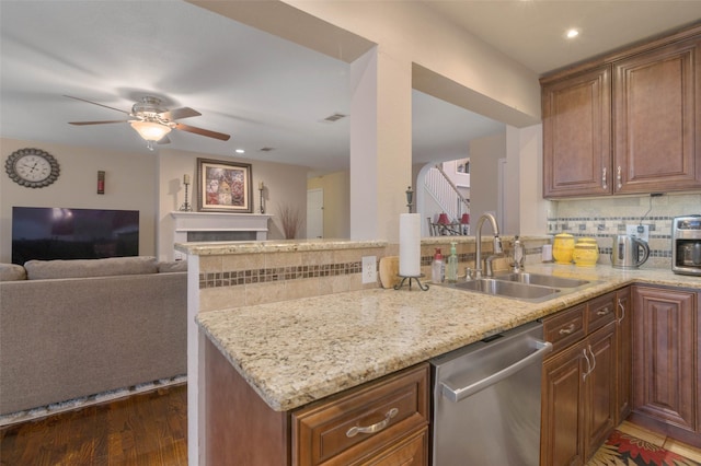 kitchen featuring sink, light stone counters, kitchen peninsula, dishwasher, and decorative backsplash