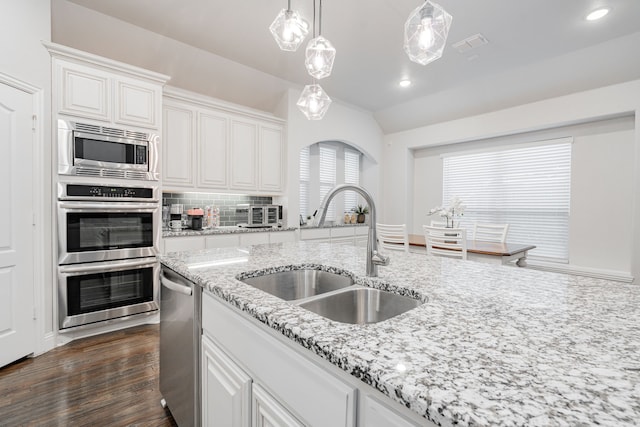 kitchen with sink, decorative backsplash, white cabinets, and appliances with stainless steel finishes