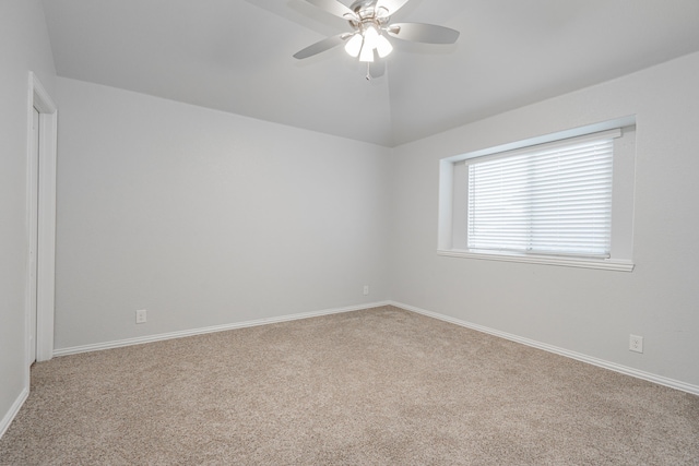 empty room featuring vaulted ceiling, light carpet, and ceiling fan