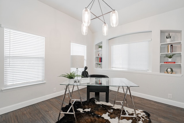 office with dark hardwood / wood-style flooring, vaulted ceiling, built in features, and an inviting chandelier