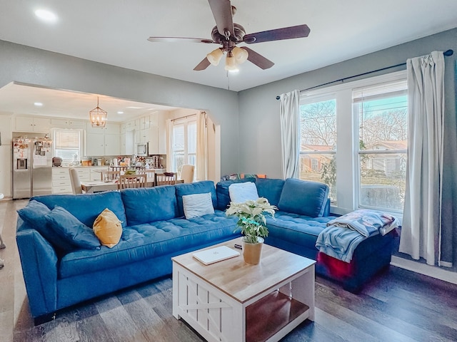 living room featuring ceiling fan with notable chandelier and hardwood / wood-style floors