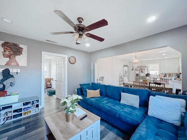 living room with dark hardwood / wood-style flooring and ceiling fan