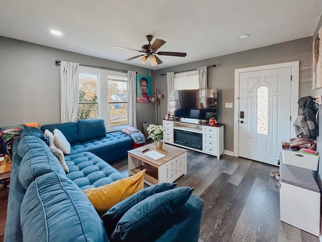 living room featuring dark wood-type flooring and ceiling fan