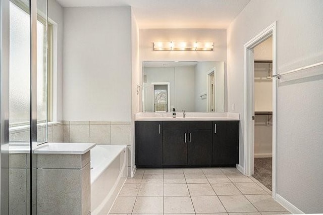 bathroom featuring vanity, a tub, and tile patterned floors