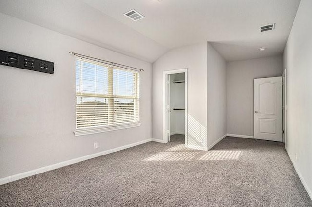 unfurnished bedroom with carpet flooring, a closet, and a spacious closet