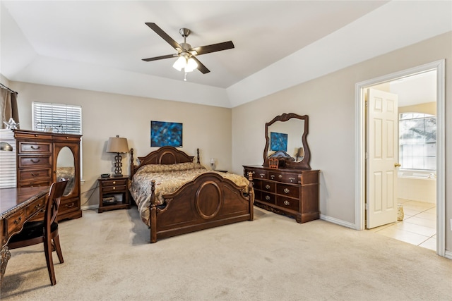 bedroom with ensuite bathroom, vaulted ceiling, light carpet, and ceiling fan