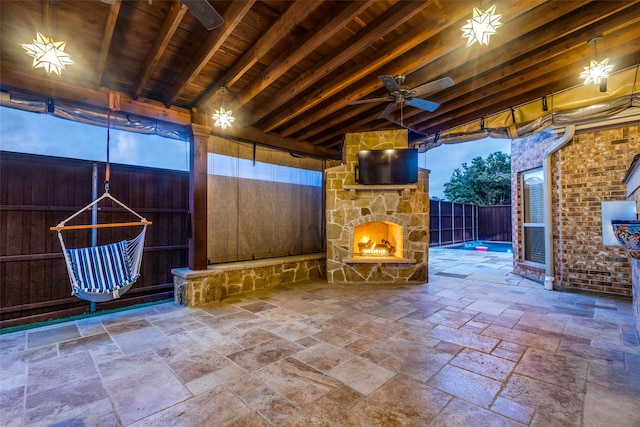 view of patio / terrace featuring ceiling fan and an outdoor stone fireplace