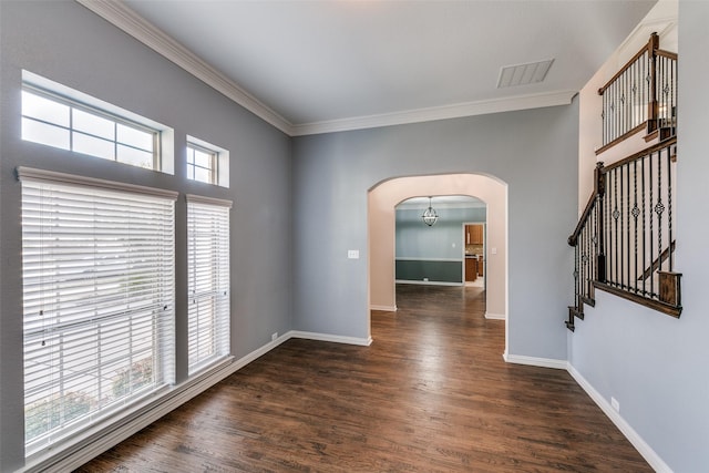 empty room featuring crown molding, a wealth of natural light, and dark hardwood / wood-style floors