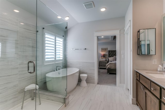 bathroom featuring vanity, separate shower and tub, and tile walls