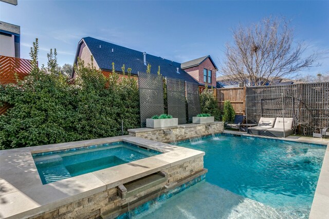 view of pool featuring pool water feature and an in ground hot tub