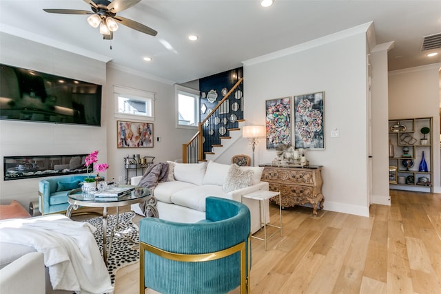 living room featuring crown molding, ceiling fan, and light hardwood / wood-style floors