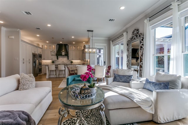 living room with crown molding and light wood-type flooring